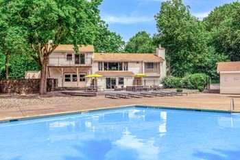 Swimming pool with patio seating and umbrellas