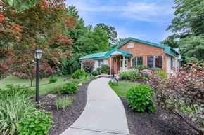 Clifton Park apartment for rent - Clubhouse entrance with curved walkway and landscaping at The Crossings at Halfmoon Apartments, Clifton Park