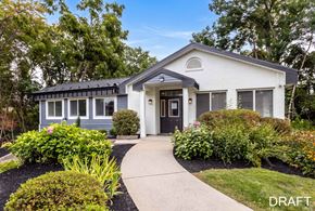 Clifton Park apartment for rent - A draft of a house with a white exterior and a black roof is surrounded by greenery.