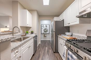 A kitchen with a stove top oven and a refrigerator.