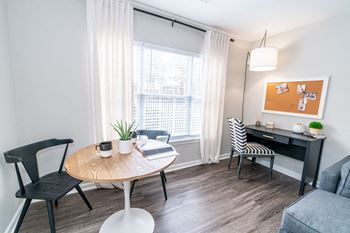 A living room with a table and chairs and a window