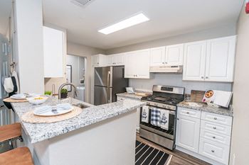 A kitchen with white cabinets and stainless steel appliances