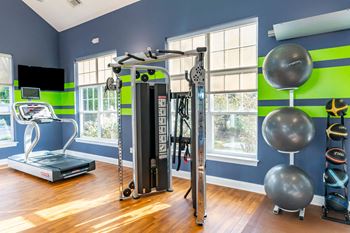 A home gym with exercise equipment and windows