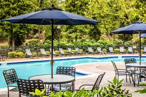 Milford apartment for rent - a swimming pool with tables and chairs and umbrellas at Merion Milford Apartment Homes, Milford, 06460