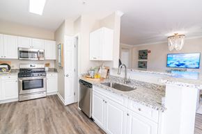 Groton apartment for rent - a kitchen with white cabinets and granite counter tops and stainless steel appliances at The Ledges Apartment Homes, Groton, CT, 06340