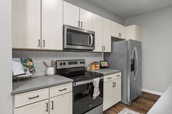 A kitchen with a stove, oven, microwave, and refrigerator.