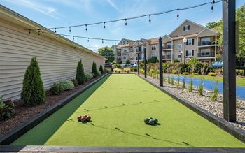 A putting green with balls on it next to a building and a river