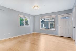 Seattle townhouse for rent - an empty living room with a hardwood floor and two windows