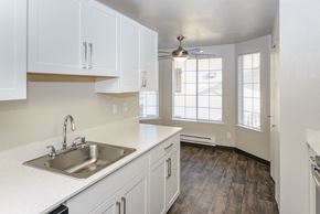 Olympia apartment for rent - an empty kitchen with white cabinets and a sink
