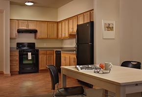 Kirkland apartment for rent - A kitchen with a black refrigerator and wooden cabinets.