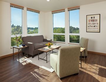 Kirkland apartment for rent - A living room with a grey couch, a white chair, and a painting on the wall.
