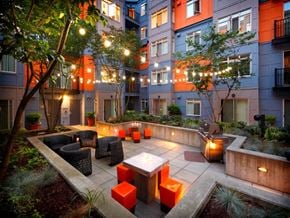 Seattle apartment for rent - a courtyard with tables and chairs and lights in an apartment building