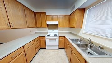 Bellingham apartment for rent - A kitchen with wooden cabinets and a white stove top oven.