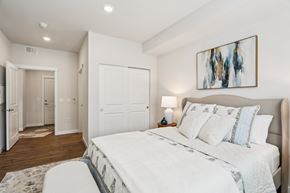 Puyallup apartment for rent - A bedroom with a large bed and a painting on the wall.