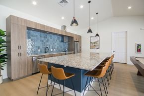 Vernal apartment for rent - A kitchen with a blue backsplash and wooden cabinets.