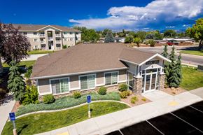 Vernal apartment for rent - A building with a brown roof and a sign that says "Welcome" in front of it.