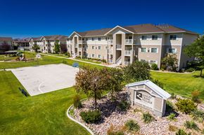 Vernal apartment for rent - A view of a Shelby Village apartment complex with a playground and a sign.