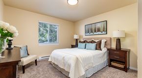 Bellingham apartment for rent - A bedroom with a bed, nightstand, and a painting on the wall.