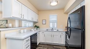 Bellingham apartment for rent - A kitchen with white cabinets and a black refrigerator.