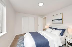 Burien apartment for rent - A bedroom with a large bed and a picture on the wall.