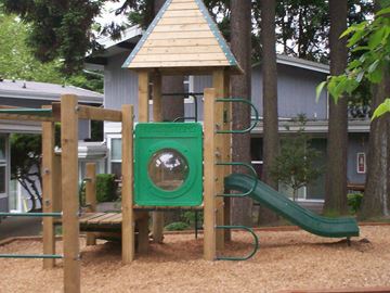 Bellevue apartment for rent - A playground with a green slide and a wooden structure.