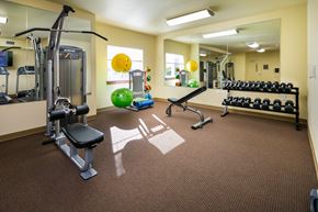 Auburn apartment for rent - a gym with weights and other equipment in a room with a mirror