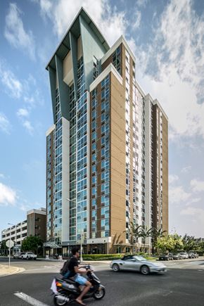 Honolulu apartment for rent - a man riding a motorcycle in front of a tall building