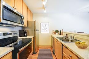 Seattle apartment for rent - A kitchen with a black stove top oven and a black microwave above it.