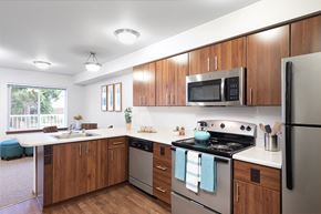 Lynnwood apartment for rent - a kitchen with stainless steel appliances and wooden cabinets