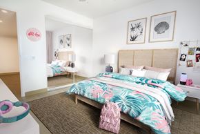 Kapolei apartment for rent - A bedroom with a bed, a nightstand, and a wall-mounted shelf with pictures and a lamp.