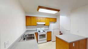 Bellingham apartment for rent - an empty kitchen with white appliances and wooden cabinets