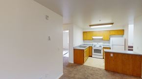 Bellingham apartment for rent - an empty kitchen with white appliances and wooden cabinets