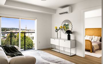 Seattle apartment for rent - A living room with a white sofa and a bed with a wooden headboard.