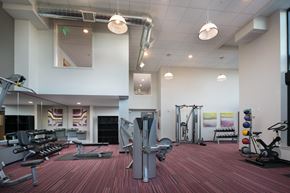 Lynnwood apartment for rent - a gym with cardio equipment and weights on a wooden floor