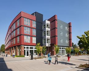 Seattle apartment for rent - a red and gray building with people walking in front of it
