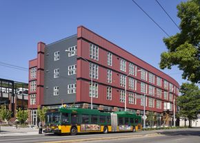 Seattle apartment for rent - a green and yellow bus is parked in front of a red building