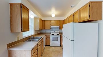 Bellingham apartment for rent - A kitchen with wooden cabinets and a white refrigerator.