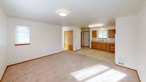 Bellingham apartment for rent - the living room and kitchen of an empty house with white walls and carpet