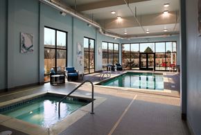 Renton apartment for rent - a swimming pool in a large room with glass doors and a windowed pool area