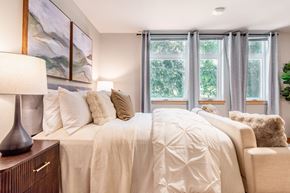 Bothell apartment for rent - A bedroom with a large bed and a painting on the wall.