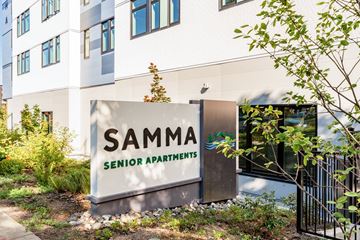 Bothell apartment for rent - A sign for Samma Senior Apartments is in front of a building.