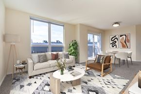 Seattle apartment for rent - A living room with a couch, a chair, a table, and a potted plant.