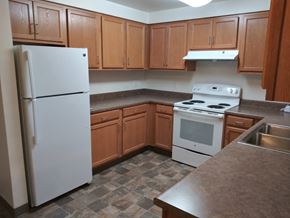 Bellingham apartment for rent - an empty kitchen with white appliances and wooden cabinets