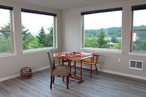 Bellevue apartment for rent - A dining room with a table set for two and a view of trees outside the window.