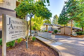 Issaquah apartment for rent - A sign for Johnson Hill Apartments is in front of a building.