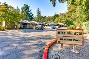 Issaquah apartment for rent - A sign for Mine Hill Apts stands in front of a parking lot.