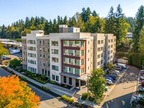 Kirkland apartment for rent - A large building with a parking lot in front of it.