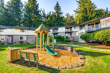 Issaquah apartment for rent - A playground with a green slide and a wooden bench.
