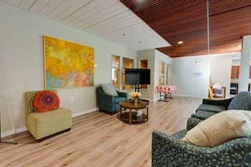 Bellevue apartment for rent - A living room with a green chair and a painting on the wall.