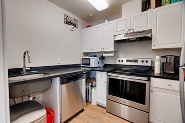 Issaquah apartment for rent - A kitchen with white cabinets and black countertops.
